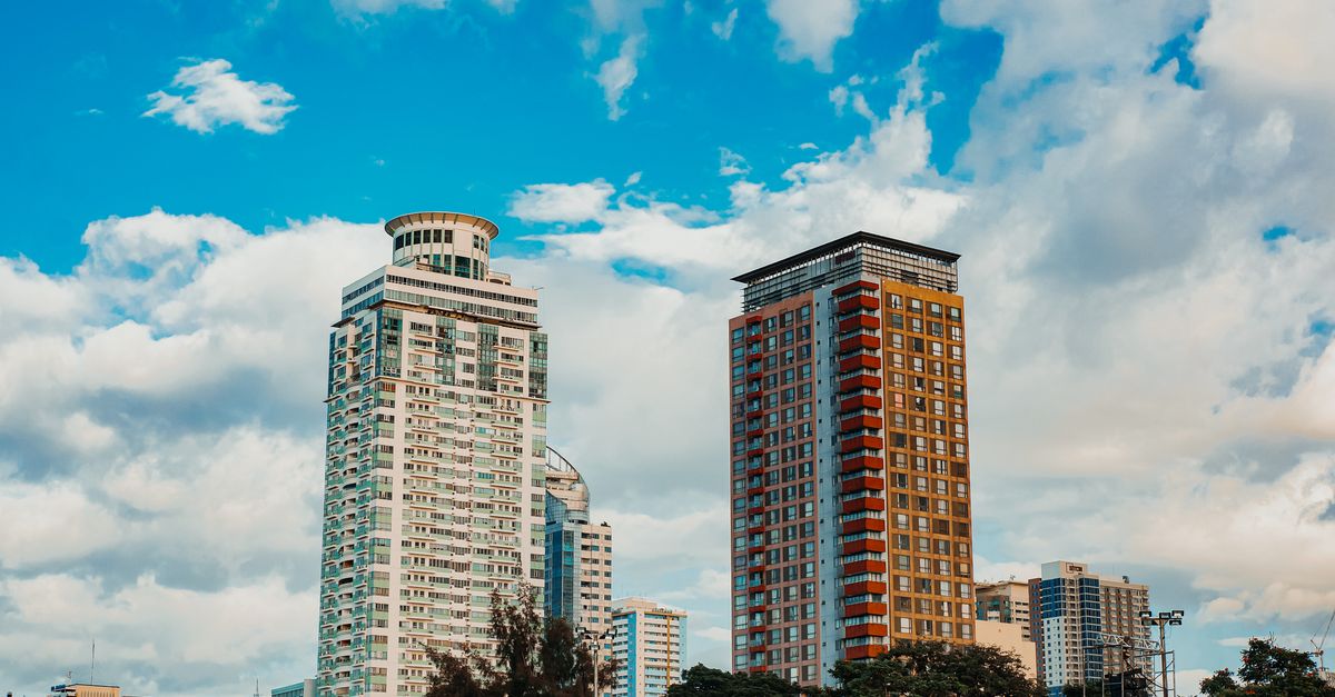 Modern skyscrapers in Manila's skyline against a vibrant sky.