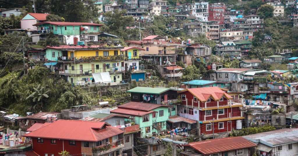 A vibrant hillside residential area in Baguio City, showcasing colorful houses nestled among lush greenery.