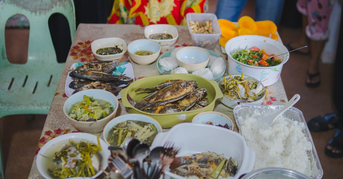 A vibrant spread of traditional Filipino dishes including fried fish and assorted side dishes on a table.