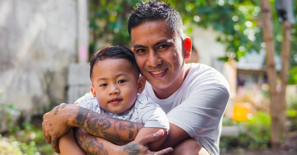 A joyful father embraces his young son outdoors, showcasing love and family bonding.