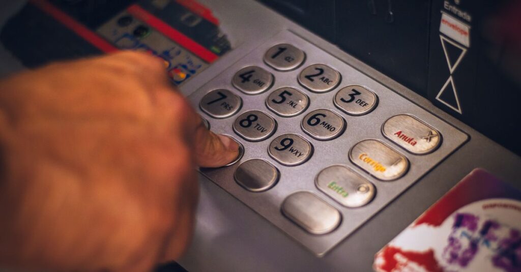 A hand pressing a button on an ATM keypad in Brasil, emphasizing digital banking.