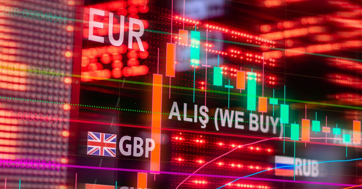 Dynamic forex trading concept with currency symbols and candlestick chart illuminated on screen.
