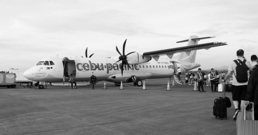 Cebu Pacific airplane at the airport with passengers boarding for departure.