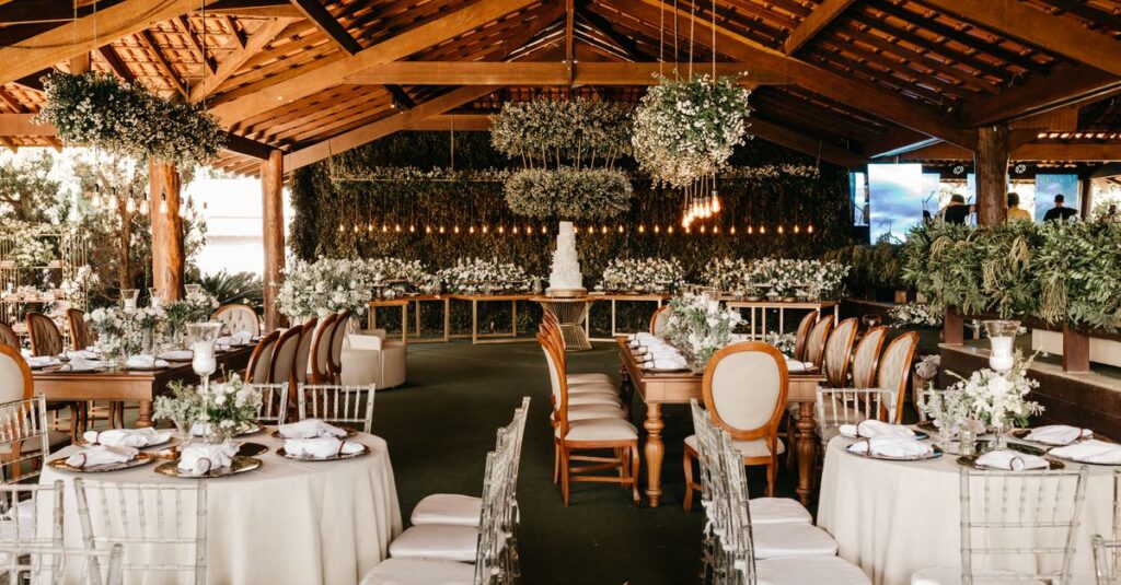 Beautifully arranged wedding reception under a wooden canopy featuring elegant decor and floral arrangements.