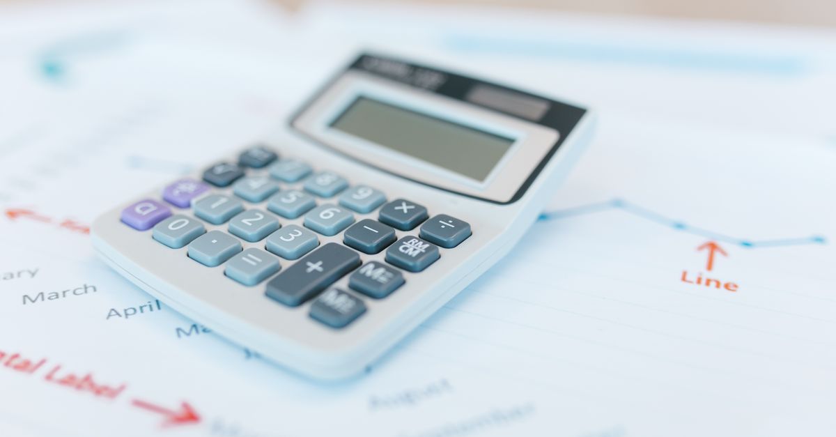 Close-up of a calculator on financial documents with graphs and analysis papers.